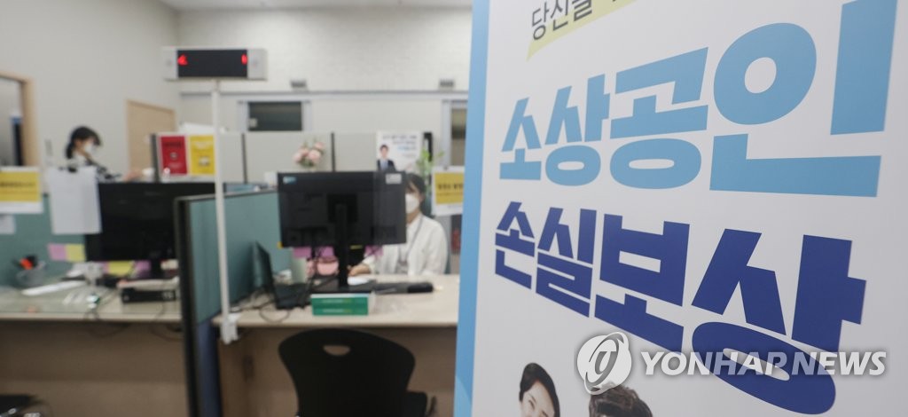 This file photo, taken June 30, 2022, shows a banner set up at an agency designed to support small merchants in Seoul that says pandemic-hit merchants can apply for state compensation for their losses caused by the government's virus restrictions. (Yonhap)
