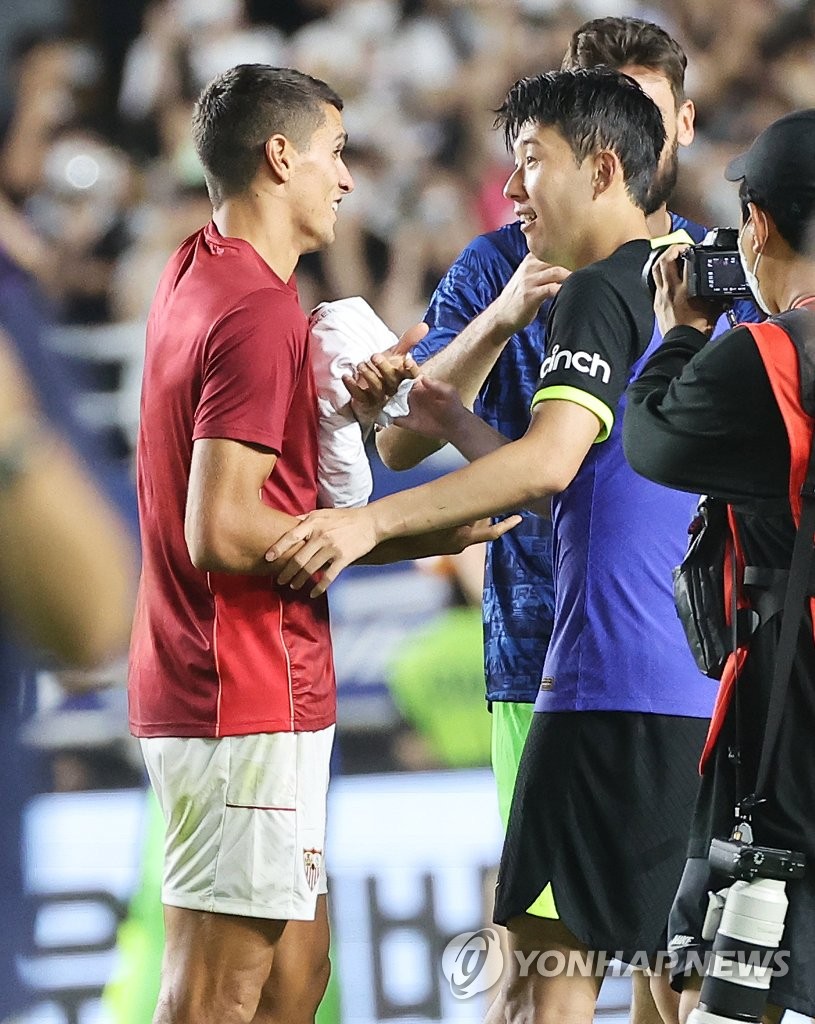 Son Heung-min (R) of Tottenham Hotspur greets Erik Lamela of Sevilla FC, his former Tottenham teammate, after the clubs' preseason match at Suwon World Cup Stadium in Suwon, Gyeonggi Province, on July 16, 2022. (Yonhap)