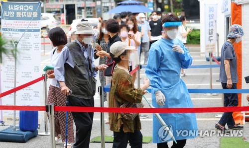 ソウル市内の新型コロナウイルス検査所で順番を待つ人々＝１８日、ソウル（聯合ニュース）