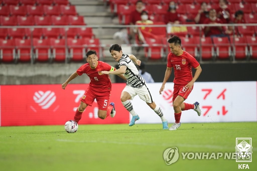Um Won-sang of South Korea (C) tries to sprint past Zhu Chenjie (L) and Wen Jiabao of China during the teams' first match at the East Asian Football Federation E-1 Football Championship at Toyota Stadium in Toyota, Japan, on July 20, 2022, in this photo provided by the Korea Football Association. (PHOTO NOT FOR SALE) (Yonhap)