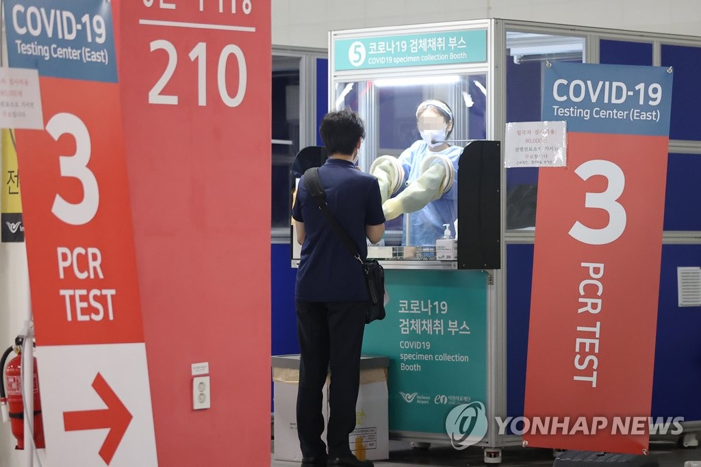 海外から仁川国際空港に到着した人が新型コロナ検査センターで検体を採取している＝２４日、仁川（聯合ニュース）