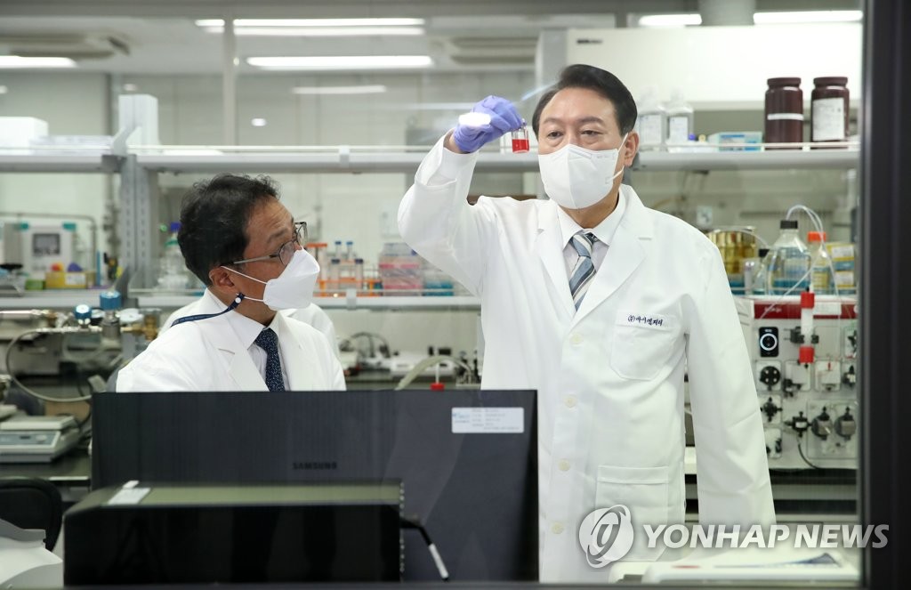 President Yoon Suk-yeol (R) visits a laboratory of IMage Guided Therapy Co., a developer of a nanotechnology-based gene and drug delivery system, prior to attending an emergency economic meeting at a health care innovation facility in Seongnam, south of Seoul, on July 27, 2022. (Pool photo) (Yonhap)