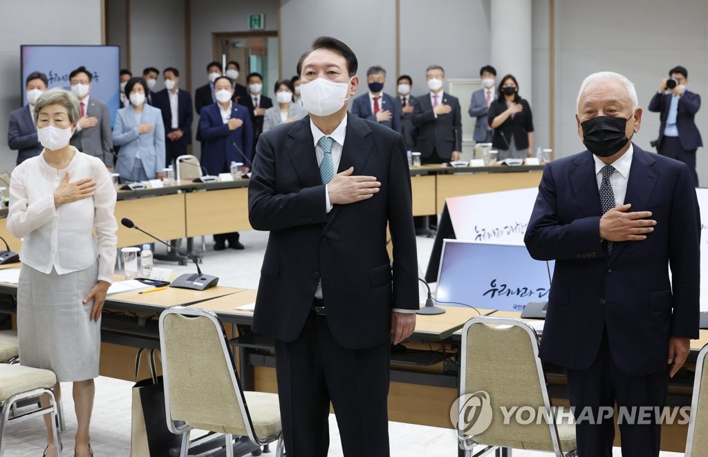 President Yoon Suk-yeol (C) salutes the national flag during a ceremony to launch the Presidential Committee of National Unity at the presidential office in Seoul on July 27, 2022. On the right is the panel's inaugural head, Kim Han-gil. (Yonhap)