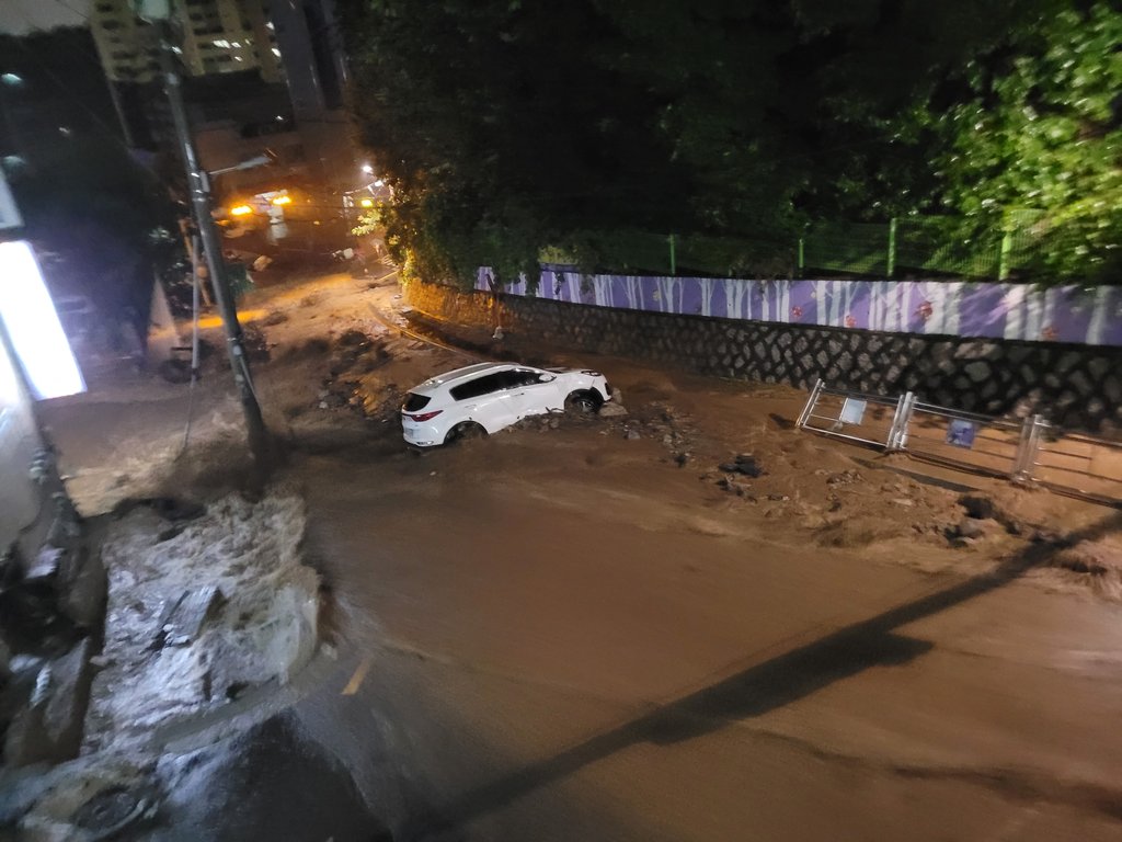 This photo provided by a news reader shows a car stuck in mud in a residential area in Seongnam, Gyeonggi Province, on Aug. 9, 2022. (PHOTO NOT FOR SALE) (Yonhap)