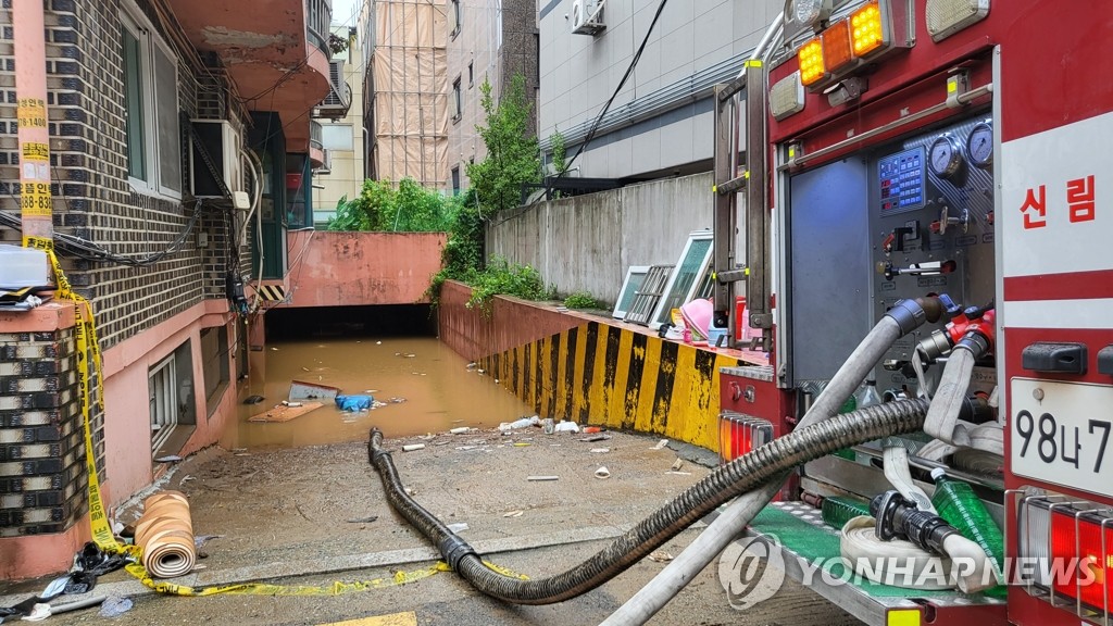 浸水した住宅の排水作業の様子＝９日、ソウル（聯合ニュース）