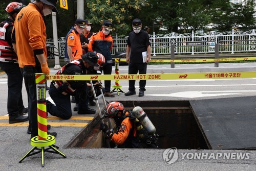 La foto, tomada el 10 de agosto de 2022, muestra a los rescatistas llevando a cabo operaciones de búsqueda en una alcantarilla, cerca de la estación de Gangnam, en el sur en Seúl, tras fuertes lluvias.