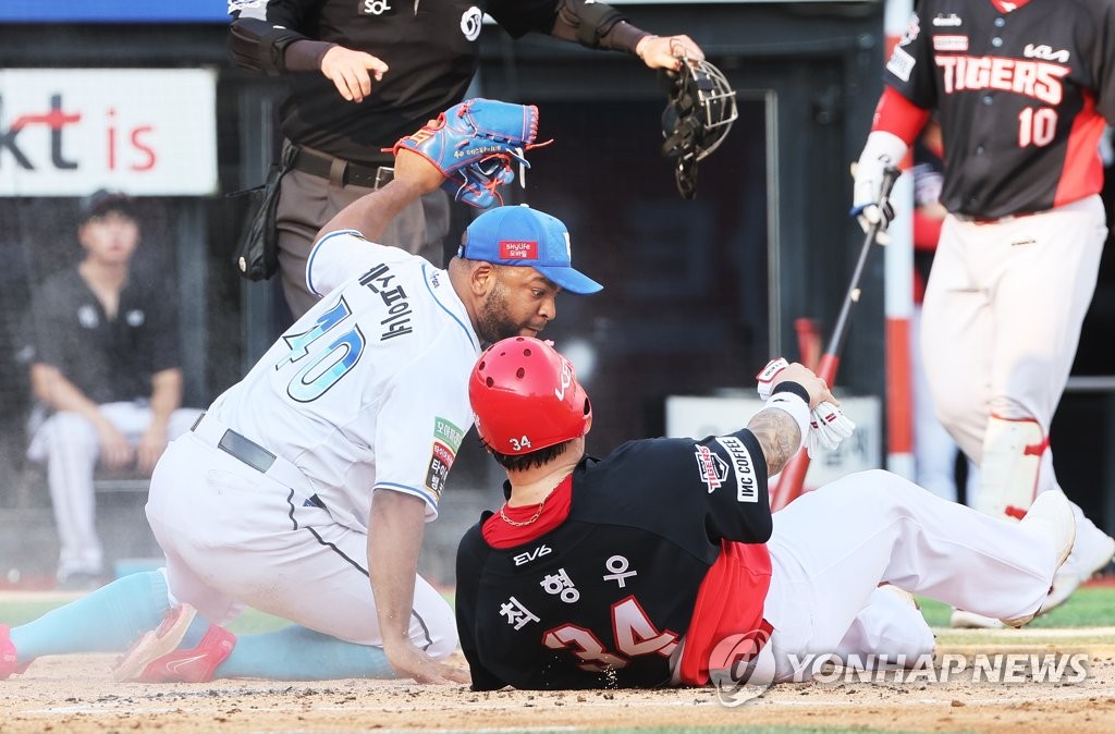 Choi Hyoung-woo of the Kia Tigers (R) slides home safely after a wild pitch thrown by Odrisamer Despaigne of the KT Wiz (L) during the top of the second inning of a Korea Baseball Organization regular season game at KT Wiz Park in Suwon, nearly 35 kilometers south of Seoul, on Aug. 21, 2022. (Yonhap)
