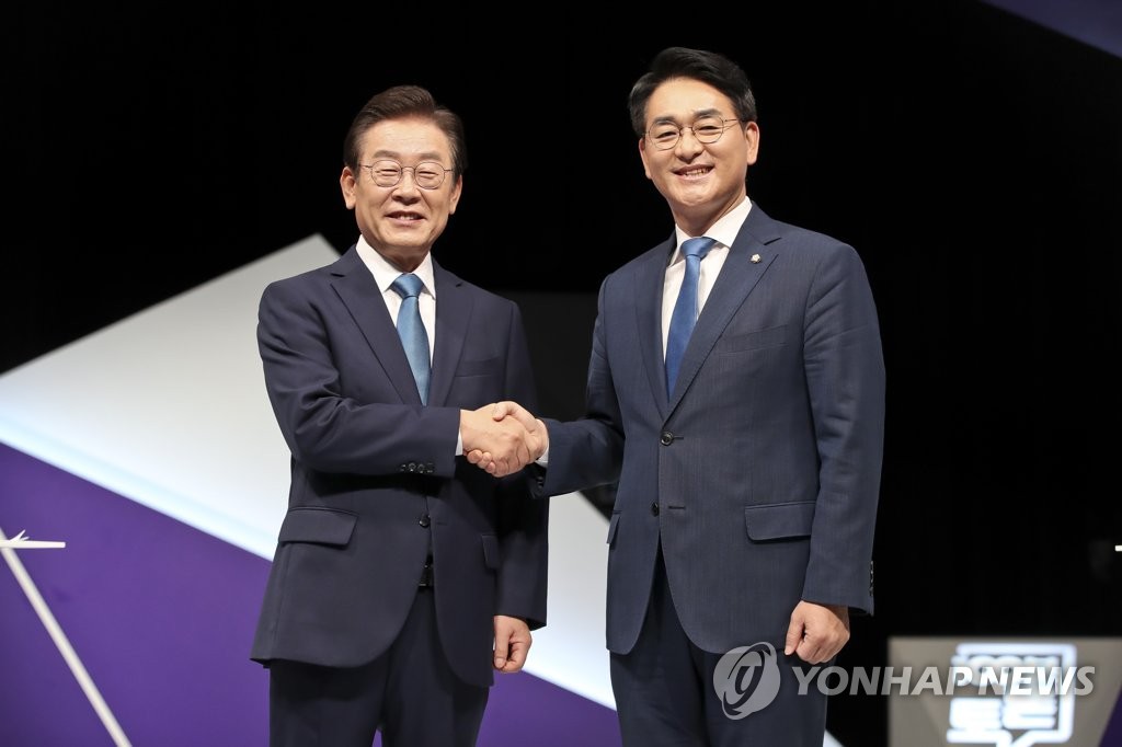 Democratic Party (DP) chairmanship candidates Reps. Lee Jae-myung (L) and Park Yong-jin shake hands ahead of a televised debate at local broadcaster MBC on Aug. 23, 2022. (Pool photo) (Yonhap)