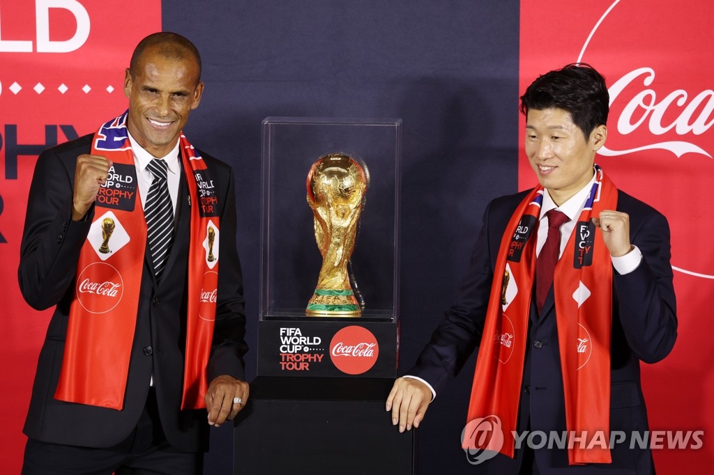 Former Brazil football star Rivaldo (L) and ex-South Korea captain Park Ji-sung pose next to the FIFA World Cup Trophy during a media showcase in Seoul on Aug. 24, 2022. (Yonhap)