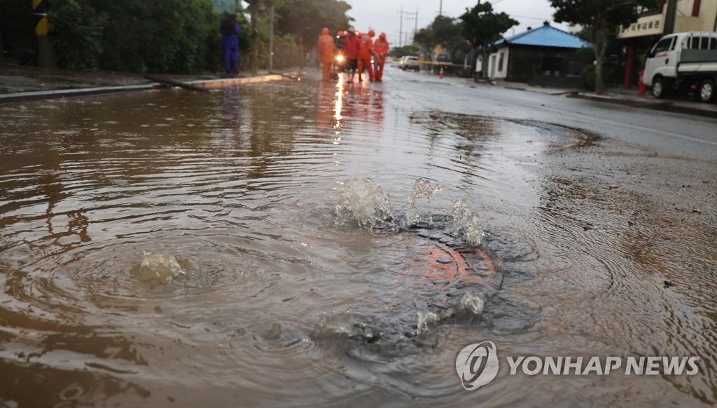 La foto, tomada el 4 de septiembre de 2022, muestra un desagüe inundado, en una calle de la isla sureña de Jeju, mientras el tifón Hinnanmor viaja hacia la península coreana.