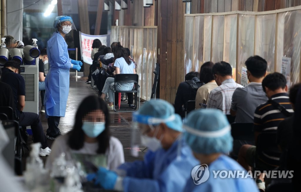 Los ciudadanos esperan en fila para ser examinados del coronavirus, el 5 de septiembre de 2022, en una clínica provisional en el distrito oriental de Songpa, en Seúl.