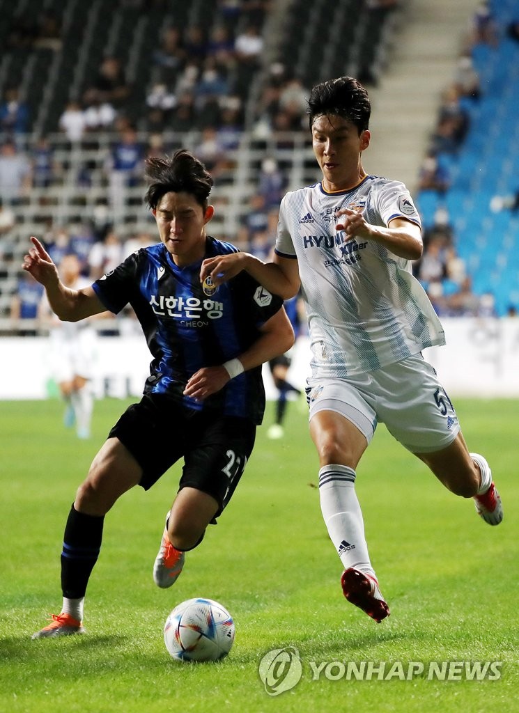 Kim Bo-sub of Incheon United (L) and Lim Jong-eun of Ulsan Hyundai FC battle for the ball during the clubs' K League 1 match at Incheon Football Stadium in Incheon, about 30 kilometers west of Seoul, on Sept. 14, 2022. (Yonhap)