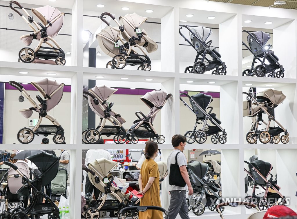 La foto de archivo muestra a visitantes recorriendo una exhibición de productos para bebés, el 15 de septiembre de 2022, en Seúl.