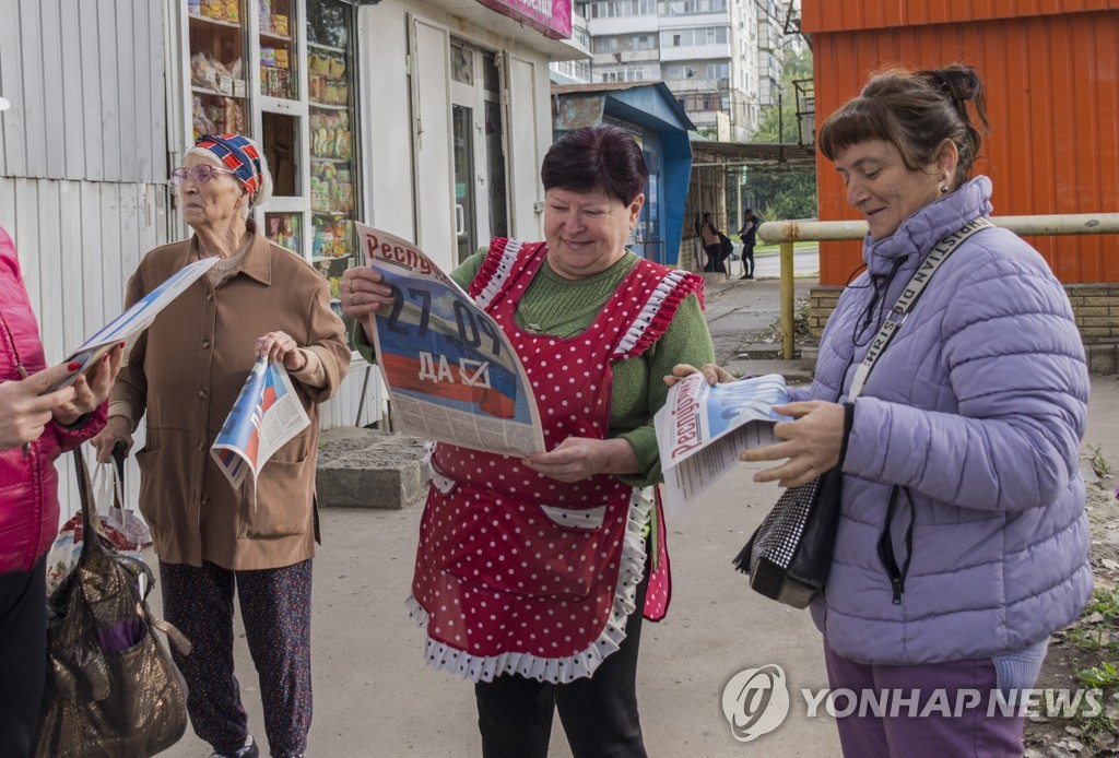 러시아 귀속투표 홍보물 읽는 루한스크 주민들