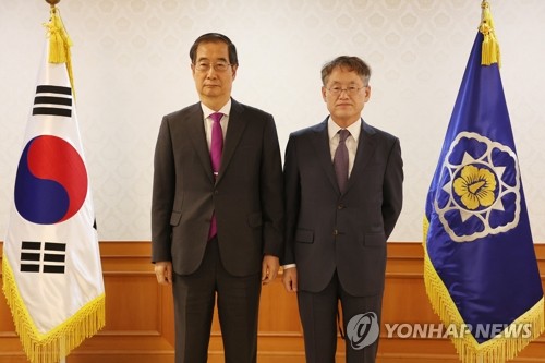 En la foto de archivo se muestra al primer ministro, Han Duck-soo (izda.), posando ante la cámara, el 30 de septiembre de 2022, con el nominado a embajador para la cooperación con la Oficina Internacional de Exposiciones (BIE, según sus siglas en francés), Choi Kyong-lim.