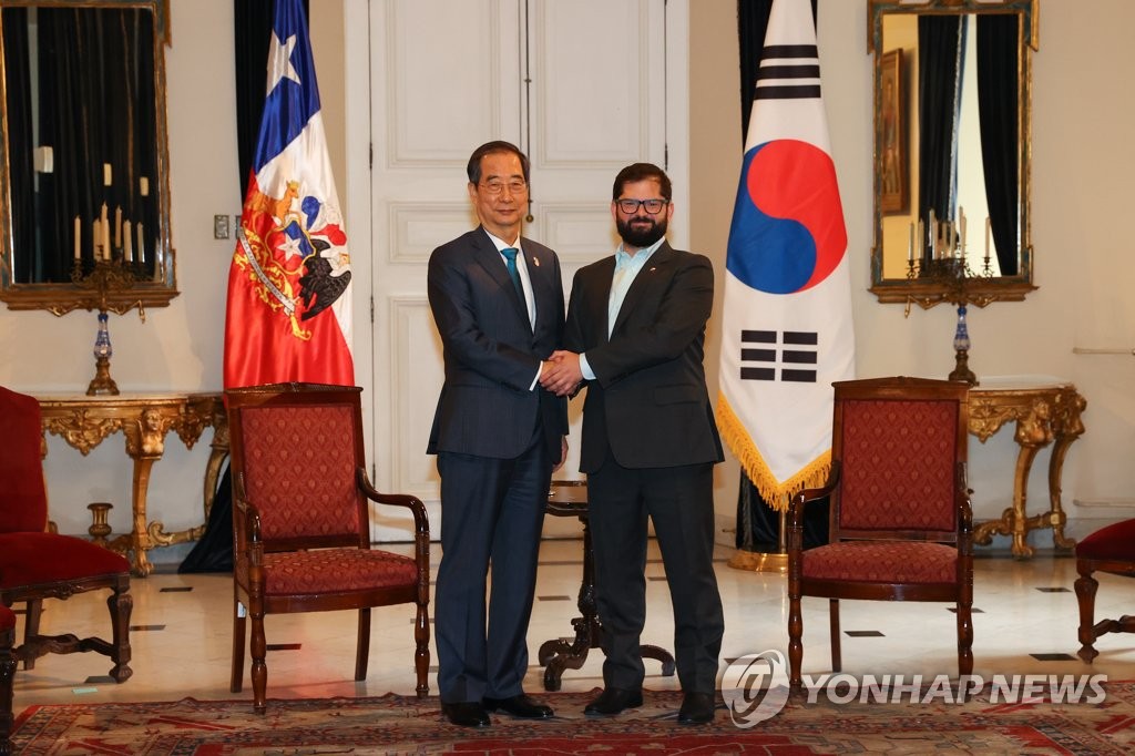 South Korean Prime Minister Han Duck-soo (L) and Chilean President Gabriel Boric pose for the camera before holding talks on Oct. 11, 2022, in this photo provided by Han's office. (PHOTO NOT FOR SALE) (Yonhap)