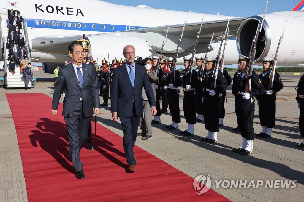 El primer ministro de Corea del Sur, Han Duck-soo (izda.), pasa revista a una guardia de honor, el 13 de octubre de 2022 (hora local), a su llegada al Aeropuerto Internacional de Ezeiza, en Buenos Aires.