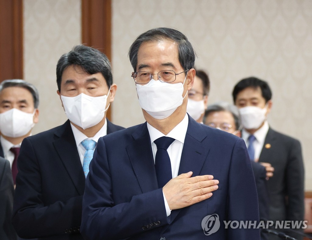 閣議で国旗に敬礼する韓国の韓首相＝８日、ソウル（聯合ニュース）