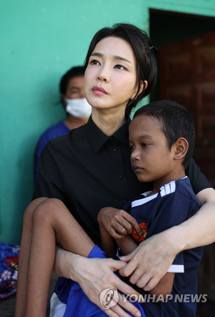 First lady Kim Keon-hee holds 14-year-old Ratha, a Cambodian child with a congenital heart disease, during a visit to his home in Phnom Penh on Nov. 12, 2022, in this photo provided by the presidential office. (PHOTO NOT FOR SALE) (Yonhap)