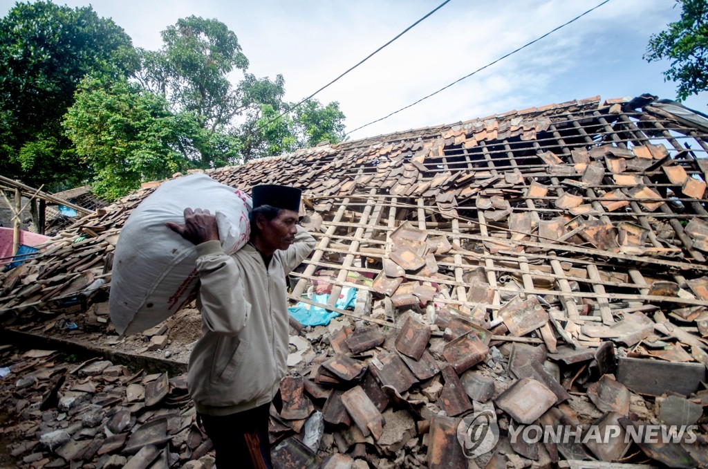 강진으로 파손된 집 지나가는 인니 치안주르 주민