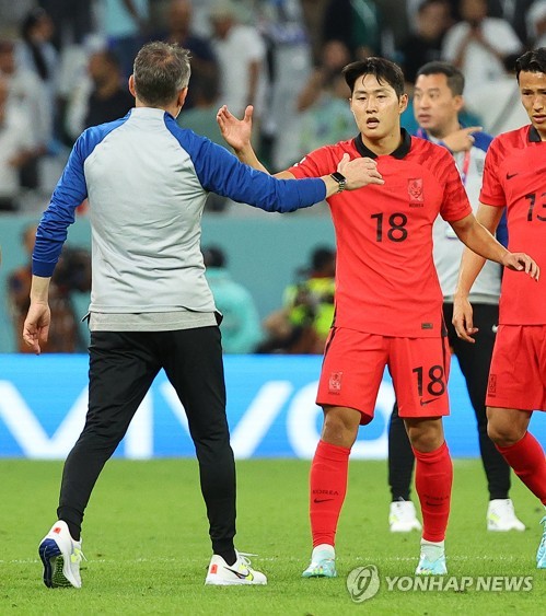 South Korea head coach Paulo Bento (L) and midfielder Lee Kang-in shake hands after a scoreless draw with Uruguay in the teams' Group H match at the FIFA World Cup at Education City Stadium in Al Rayyan, west of Doha, on Nov. 24, 2022. (Yonhap)