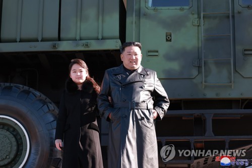 This photo, released by the Korean Central News Agency on Nov. 27, 2022, shows North Korean leader Kim Jong-un (R) with his daughter during a photo session with officials involved in this month's intercontinental ballistic missile launch. (For Use Only in the Republic of Korea. No Redistribution) (Yonhap)