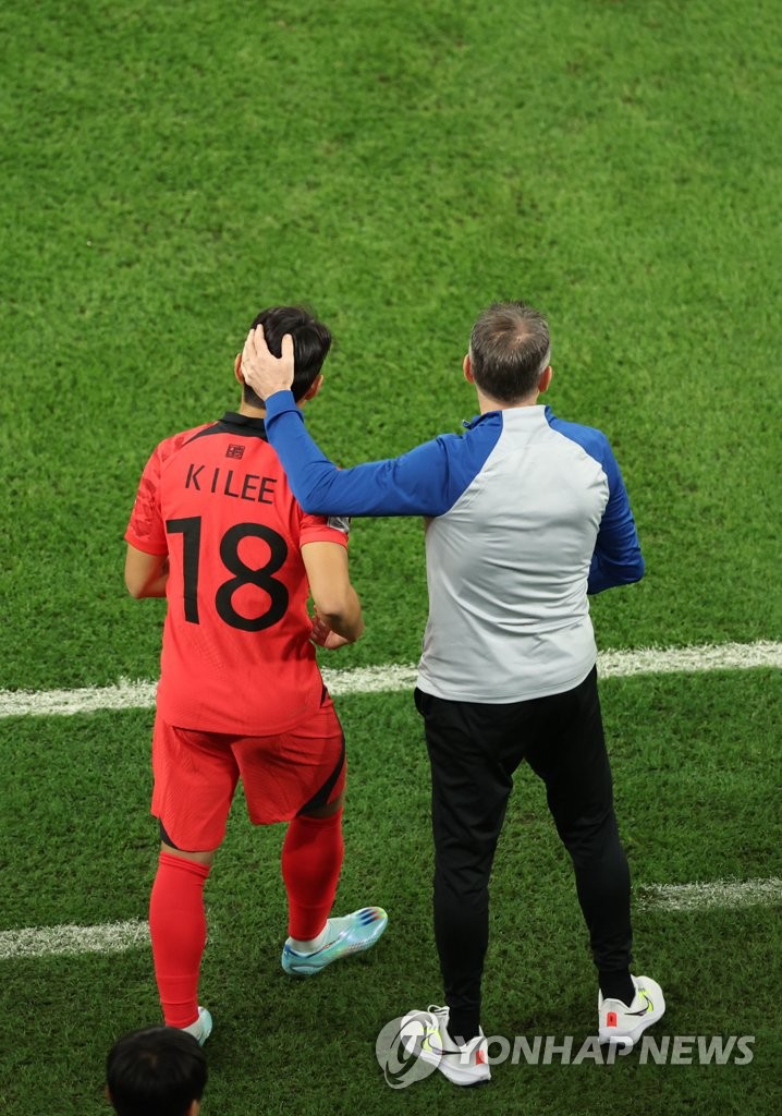 South Korea head coach Paulo Bento (R) prepares to send midfielder Lee Kang-in into the team's Group H match against Ghana at the FIFA World Cup at Education City Stadium in Al Rayyan, west of Doha, on Nov. 28, 2022. (Yonhap)