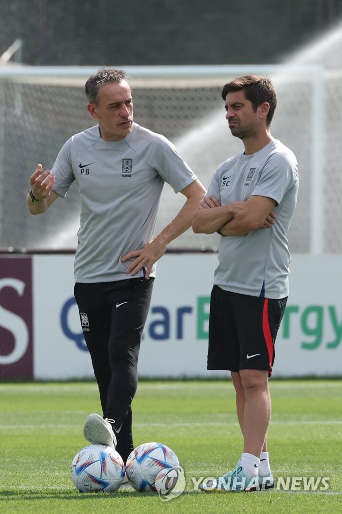 South Korea head coach Paulo Bento (L) speaks with his top assistant Sergio Costa during a training session for the FIFA World Cup at Al Egla Training Site in Doha on Dec. 1, 2022. (Yonhap)
