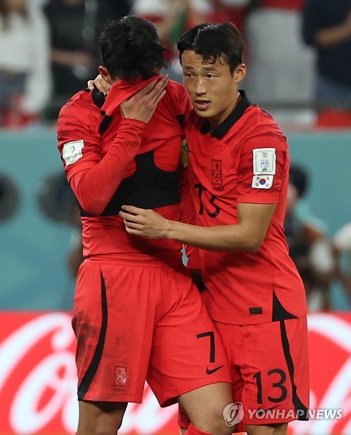 Son Heung-min of South Korea (L) cries next to teammate Son Jun-ho after their team's 2-1 victory over Portugal in a Group H match at Education City Stadium in Al Rayyan, west of Doha, that sent South Korea to the knockout stage at the FIFA World Cup on Dec. 2, 2022. (Yonhap)