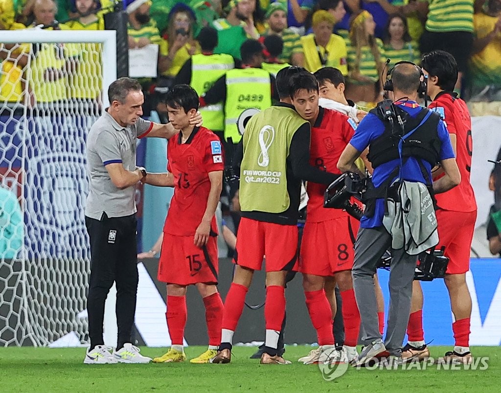 South Korea head coach Paulo Bento (L) consoles his players after their 4-1 loss to Brazil in the round of 16 at the FIFA World Cup at Stadium 974 in Doha on Dec. 5, 2022. (Yonhap)