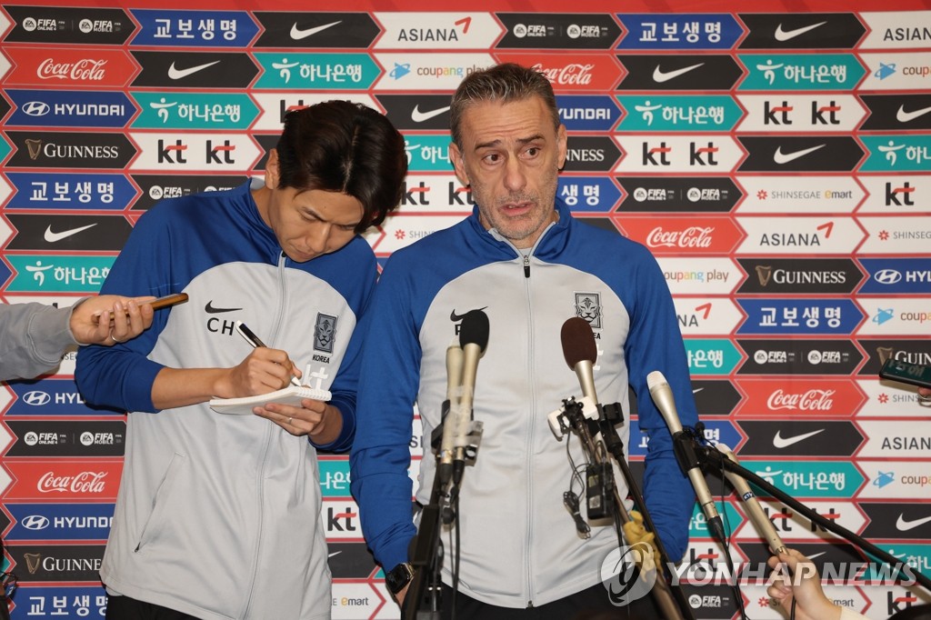 South Korea head coach Paulo Bento (R) speaks to reporters at Incheon International Airport, just west of Seoul, after returning home from the FIFA World Cup in Qatar on Dec. 7, 2022. (Yonhap)