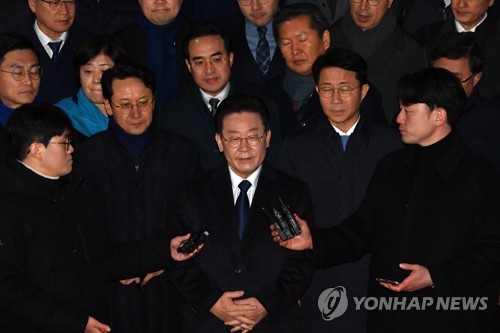 The main opposition Democratic Party leader Lee Jae-myung (C) receives reporters' questions in front of the Seongnam branch of the Suwon District Prosecutors Office in Seongnam, just south of Seoul, on Jan. 10, 2023, after being questioned by prosecutors over bribery allegations. (Pool photo) (Yonhap)