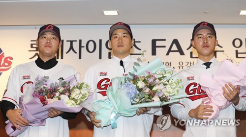 Free agent signings for the Lotte Giants pose for photos during their joint introductory press conference in Busan, 325 kilometers southeast of Seoul, on Jan. 19, 2023. From left: pitcher Han Hyun-hee, catcher Yoo Kang-nam and infielder No Jin-hyuk. (Yonhap)
