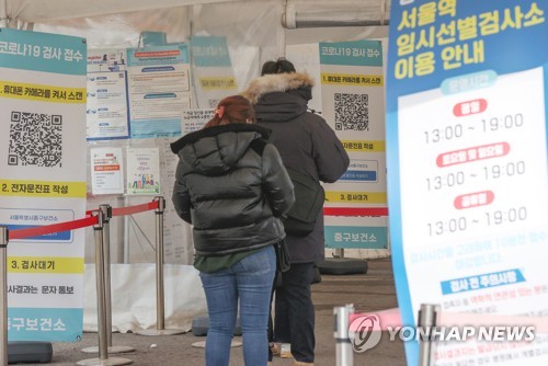 Unos ciudadanos esperan para someterse a una prueba del COVID-19, el 23 de enero de 2023, en un centro de exámenes del virus, en Seúl.
