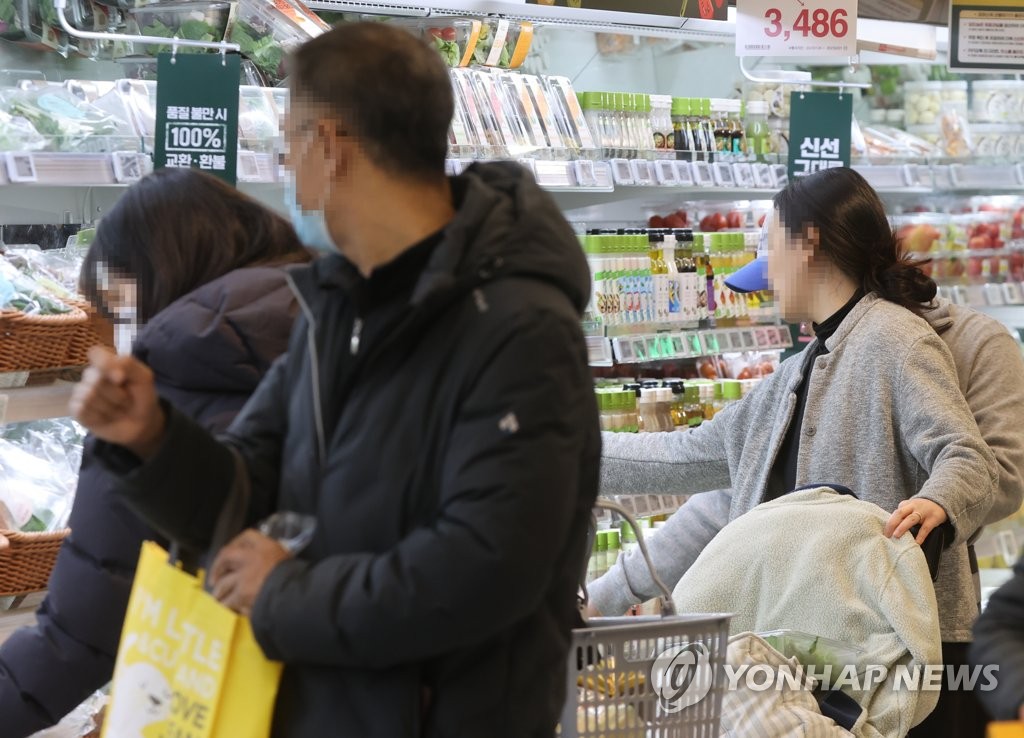 La foto, tomada el 30 de enero de 2023, muestra a ciudadanos comprando comestibles en un supermercado de Seúl.