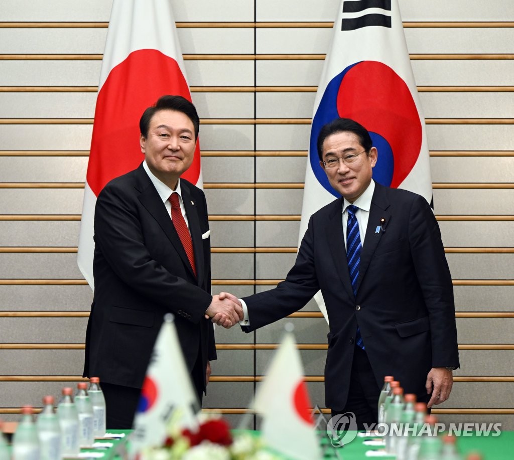 １６日の韓日首脳会談で握手を交わす尹大統領（左）と岸田首相＝（聯合ニュース）