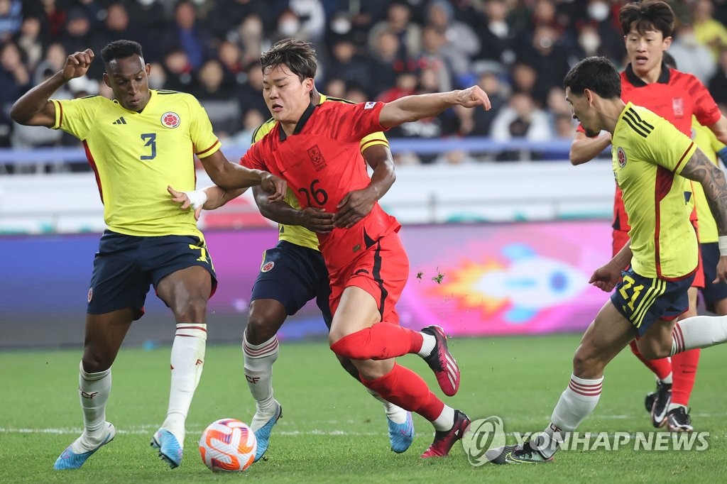 Oh Hyeon-gyu of South Korea (C) tries to dribble past Colombian players during the teams' friendly football match at Munsu Football Stadium in Ulsan, 305 kilometers southeast of Seoul, on March 24, 2023. (Yonhap)