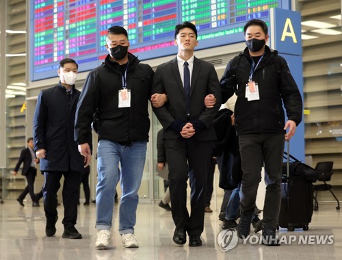 Police officers apprehend Chun Woo-won (C), a grandson of late former President Chun Doo-hwan, over suspected illegal drug use upon his arrival at Incheon International Airport on March 28, 2023. (Yonhap) 