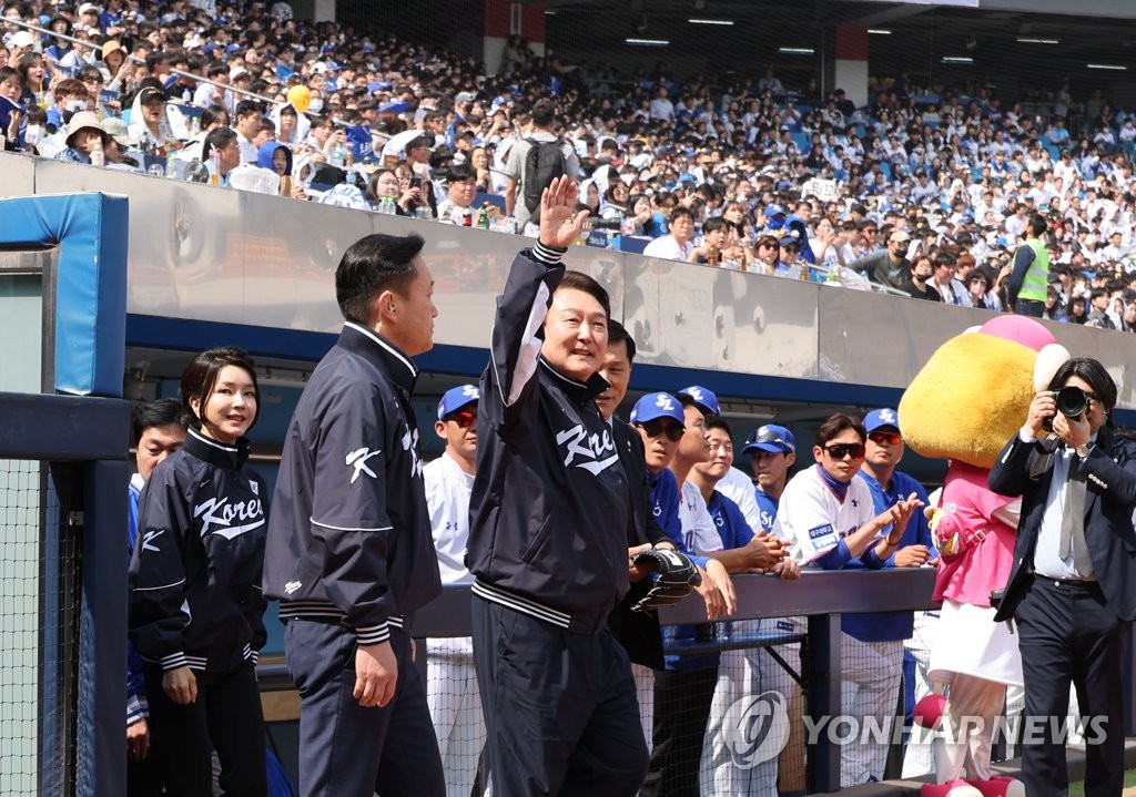 President Yoon Suk Yeol (C) waves to fans at Daegu Samsung Lions Park in Daegu, some 240 kilometers southeast of Seoul, before throwing the ceremonial first pitch before a Korea Baseball Organization Opening Day game between the Lions and the NC Dinos on April 1, 2023. (Yonhap)