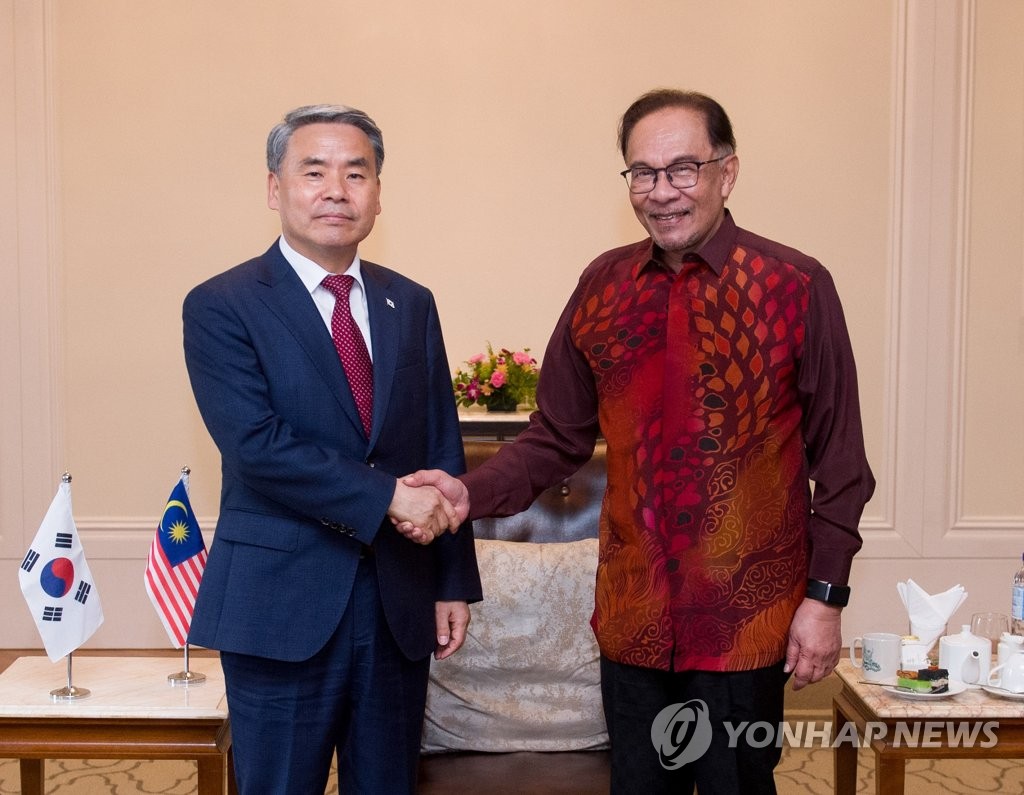 South Korean Defense Minister Lee Jong-sup (L) shakes hands with Malaysia's Prime Minister Anwar Ibrahim during their meeting in Langkawi, Malaysia on May 24, 2023, in this photo provided by Seoul's defense ministry. (PHOTO NOT FOR SALE) (Yonhap)