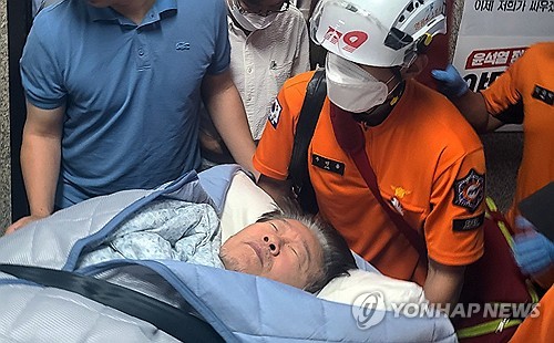 国会内の党代表室から病院に運ばれる李氏＝１８日、ソウル（聯合ニュース）