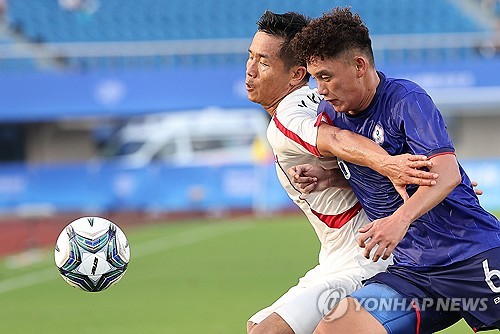 Kim Kuk-jin of North Korea (L) and Liang Meng-Hsin of Chinese Taipei battle for the ball during the teams' Group F match in men's football at the Asian Games at Zhejiang Normal University East Stadium in Jinhua, China, on Sept. 19, 2023. (Yonhap)
