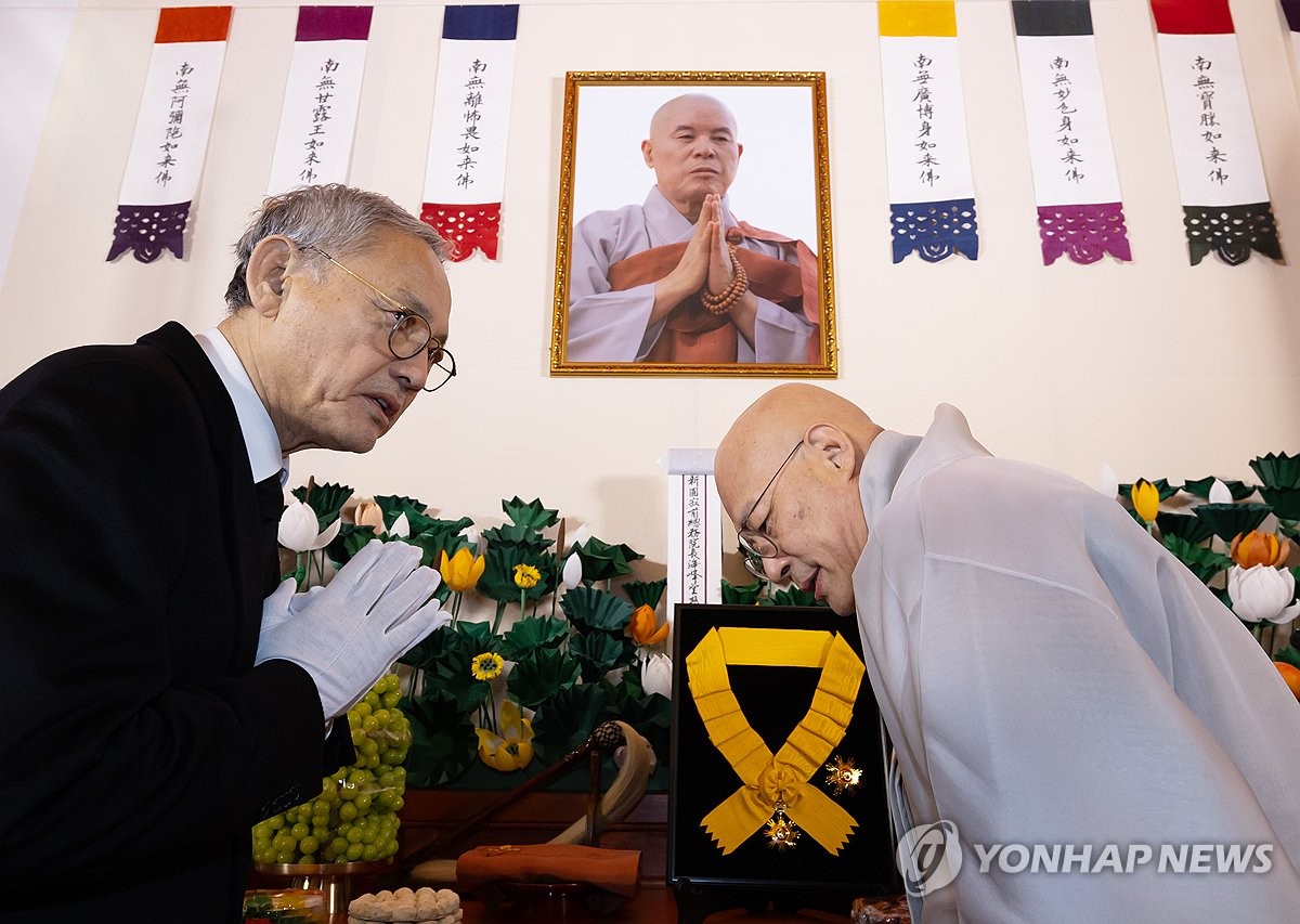 유인촌 문화체육관광부 장관이 2일 서울 종로구 조계사 대웅전에 마련된 전 조계종 총무원장 고(故) 자승스님 분향소에 정부 국민훈장 무궁화장을 추서한 뒤 조계종 총무원장 진우 스님과 합장하고 있다. / 연합뉴스