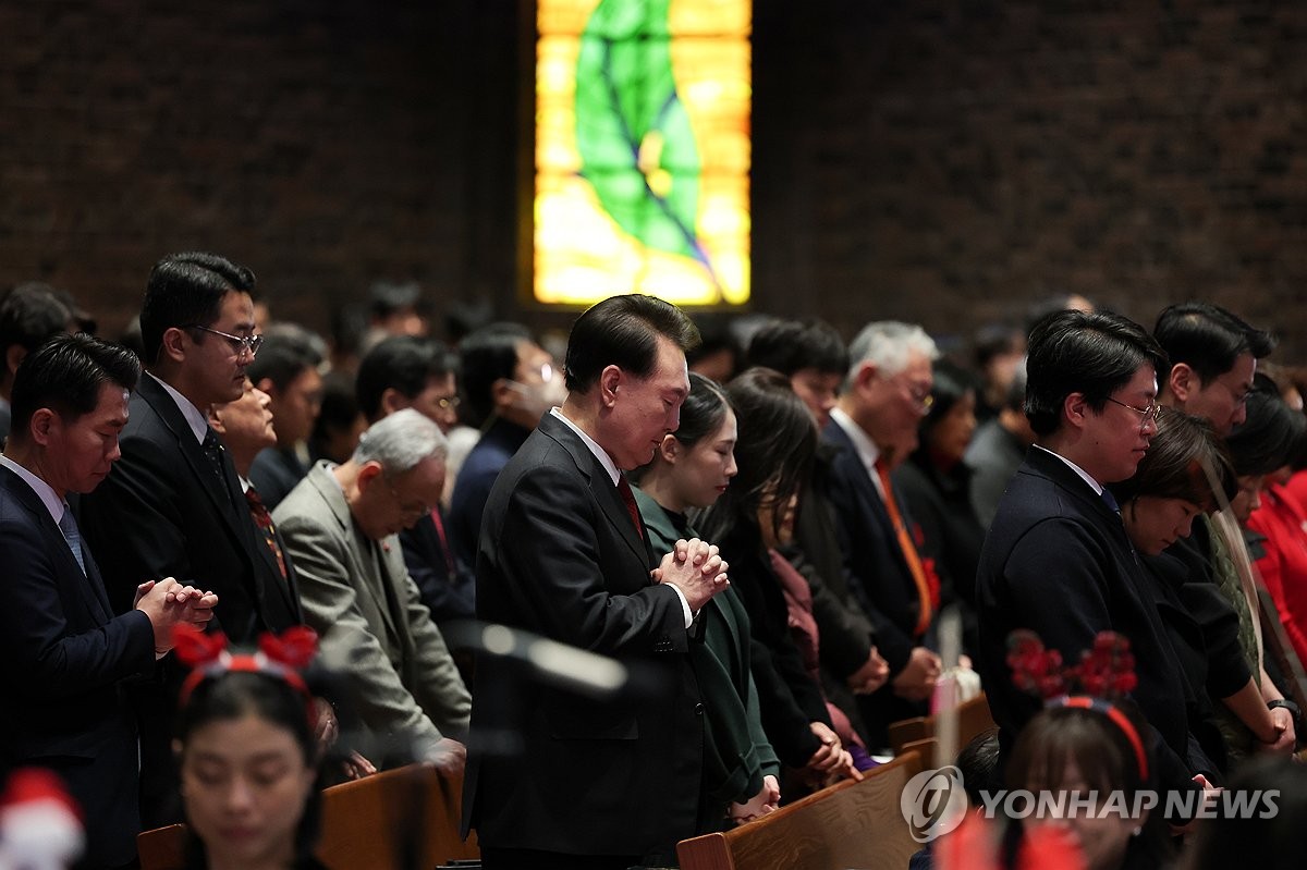 El presidente Yoon Suk Yeol (centro) asiste a un servicio navideño en la Primera Iglesia Metodista de Chungdong, en el centro de Seúl, el 25 de diciembre de 2023, en esta fotografía proporcionada por la oficina presidencial.  (FOTO NO EN VENTA) (Yonhap)