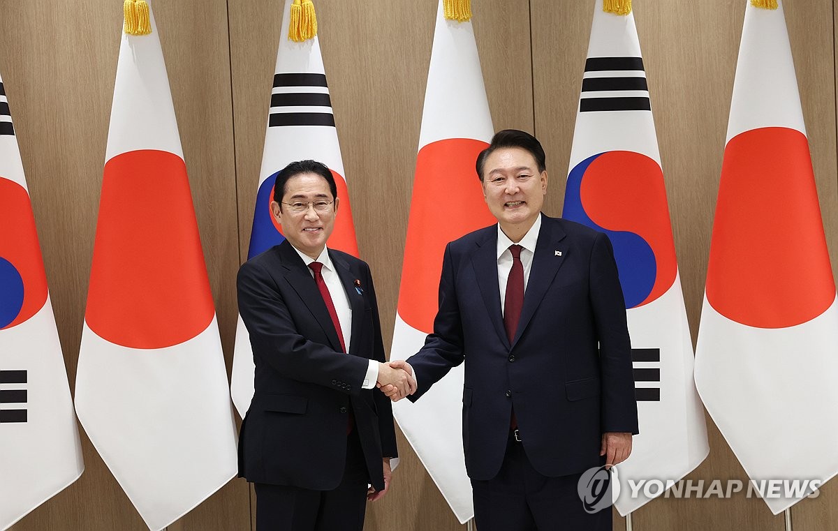 President Yoon Suk Yeol (R) shakes hands with Japanese Prime Minister Fumio Kishida during their meeting at the presidential office in Seoul on May 26, 2024. (Yonhap) 