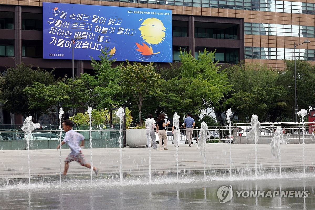 Un niño corre por una fuente en la plaza Gwanghwamun de Seúl el 11 de septiembre de 2024, en medio de una ola de calor implacable que afecta a todo el país. (Yonhap)