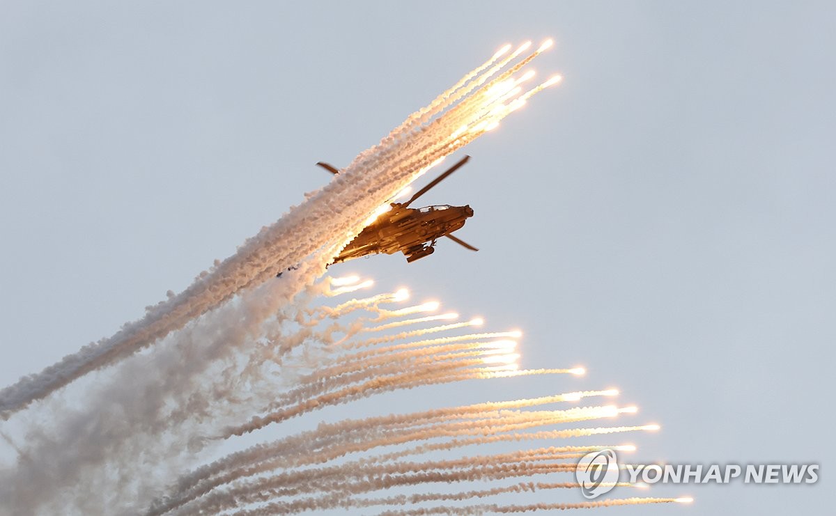 Un helicóptero de ataque Apache dispara bengalas mientras participa en la ceremonia del Día de las Fuerzas Armadas en la Base Aérea de Seúl en Seongnam, justo al sur de Seúl, el 1 de octubre de 2024. (Yonhap)