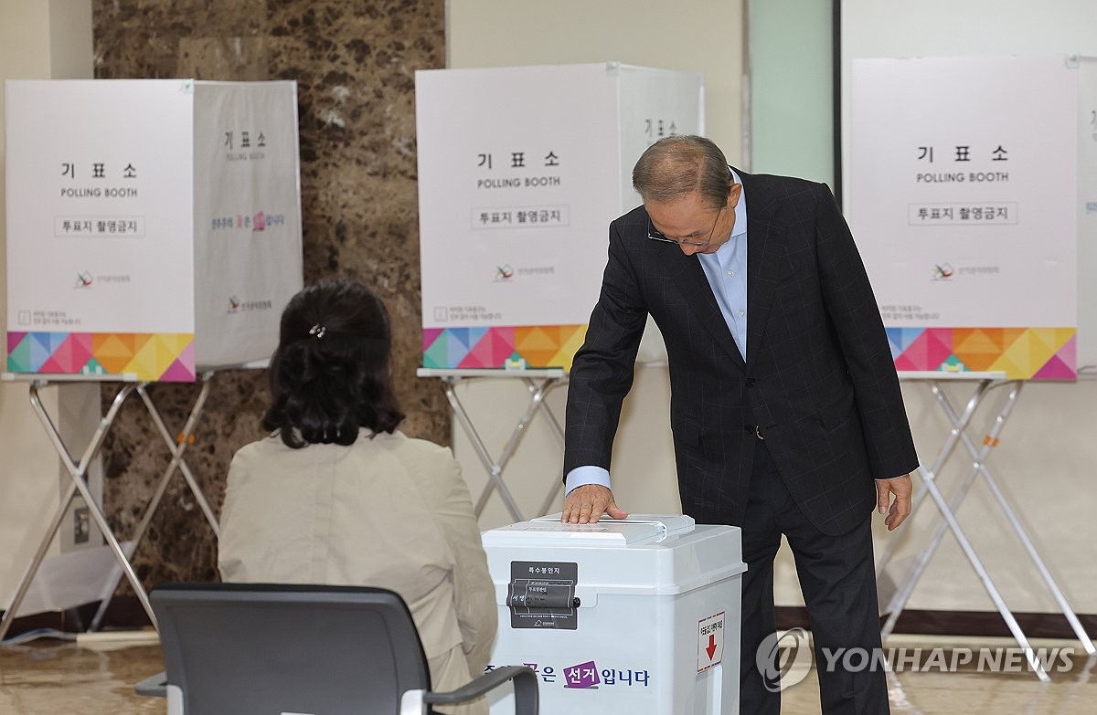 El expresidente Lee Myung-bak (R) emite su voto en un colegio electoral en Seúl el 16 de octubre de 2024, cuando comienzan las elecciones parciales para elegir un nuevo superintendente de la Oficina Metropolitana de Educación de Seúl. (Yonhap)