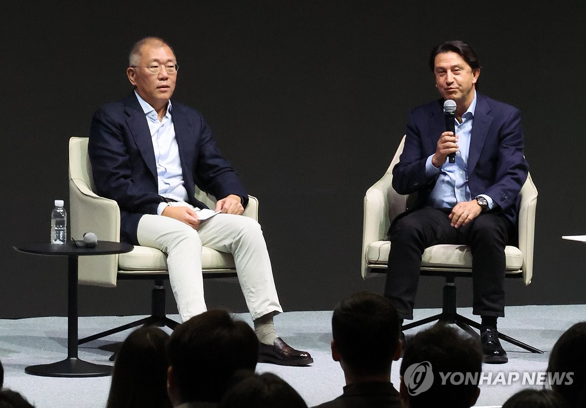 Hyundai Motor Co. CEO Jose Munoz (R) speaks next to Hyundai Motor Group Executive Chair Euisun Chung during a company meeting in Goyang, north of Seoul, in this Jan. 6, 2025, file photo. (Yonhap)