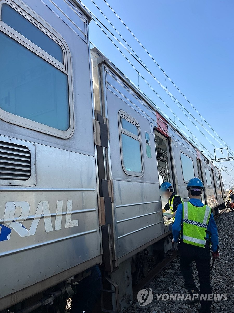 Officials inspect a train on the Gyeongui-Jungang Line after making an emergency stop in Paju, just north of Seoul, on April 11, 2025, in this photo provided by the fire authorities. (PHOTO NOT FOR SALE) (Yonhap)